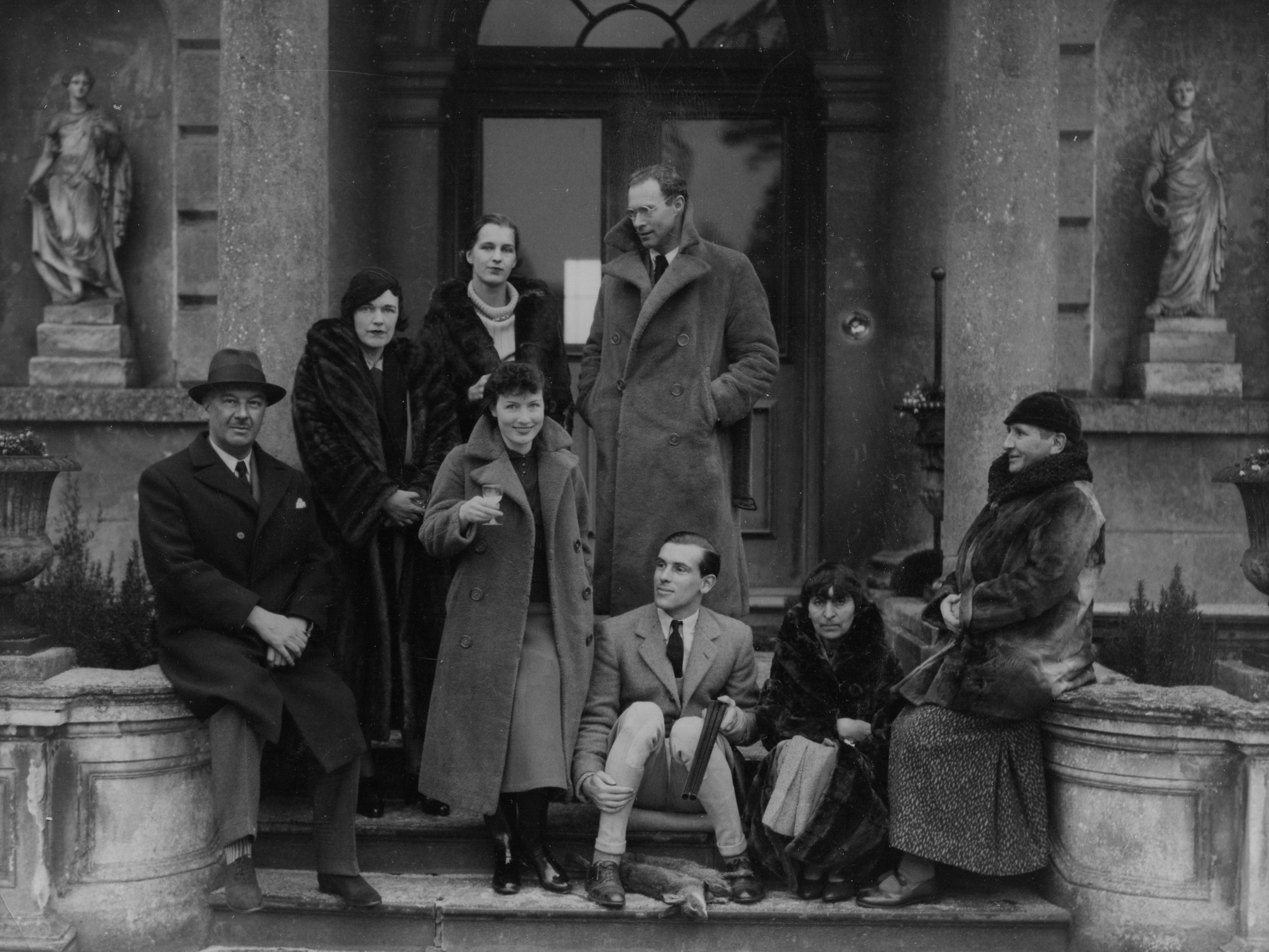 Gertrude Stein is sitting on the right, opposite Lord Berners. Their partners are sitting on the steps: Robert Hebert-Percy and Alice B. Toklas.