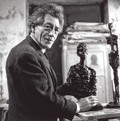 Alberto Giacometti, holding a sculpture, Paris, 1966 © Gisèle Freund